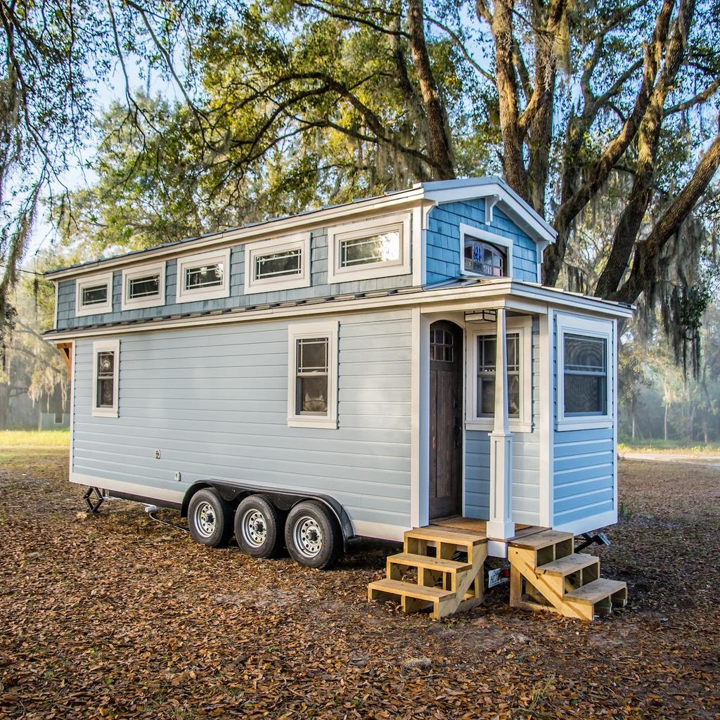 Input image for: Replace the tiny house on wheels with a vintage car.